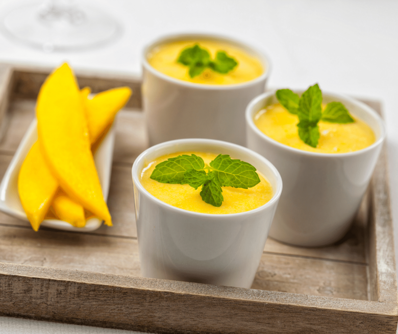 Schälchen mit Mango Mousse und Minze garniert