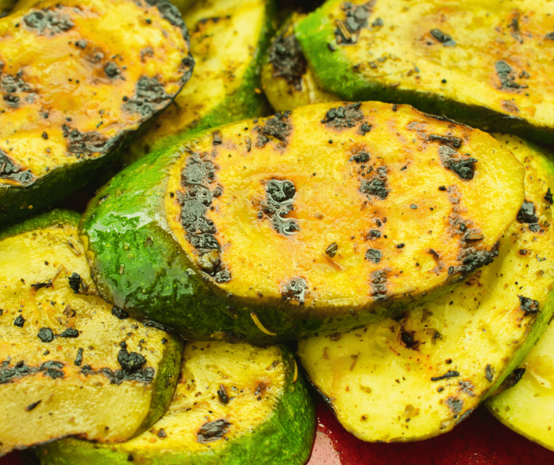 Nahaufnahme gegrillter Zucchini Taler auf rotem Teller