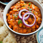Kichererbsen Curry mit Zwiebelringen und Koriander garniert