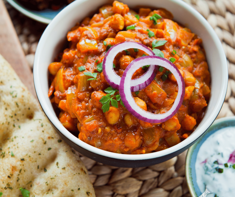 Kichererbsen Curry mit Zwiebelringen und Koriander garniert