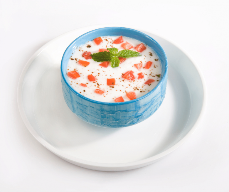 Indischer Joghurt Salat mit Tomate, in einem blauen Schüsselchen mit Minze garniert
