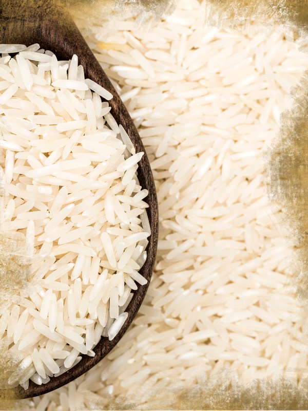 Nahaufnahme von ungekochtem Basmati Reis in einem Holzlöffel