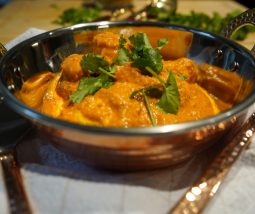 Butter Chicken | Murgh Makhani mit grünem Koriander garniert in einem Kupferschälchen angerichtet. Bereit, um gegessen zu werden.
