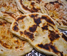 Frisch gebackenes Naan ohne Hefe aus der Pfanne, goldbraun gebraten, weich und buttrig, direkt nach dem Ausbacken serviert
