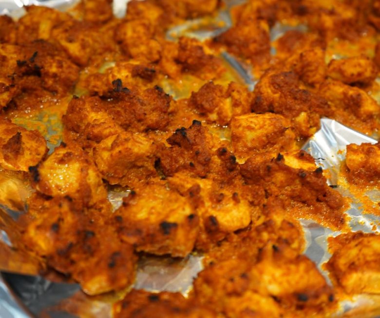 Frisch aus dem Ofen: Saftiges Hähnchen in leuchtend oranger Tandoori-Marinade